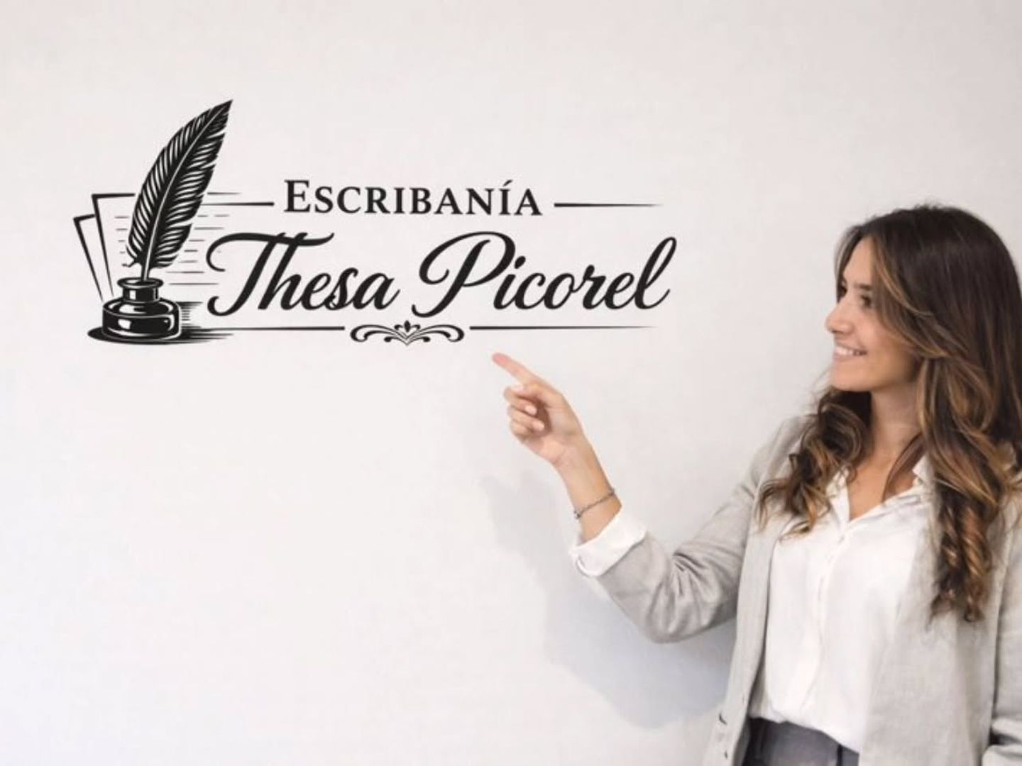 Thesa Picorel señalando el cartel de su escribanía
